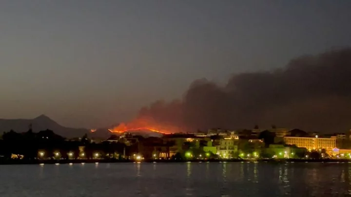 As wildfires rage in Greece, tourists flee and locals shelter